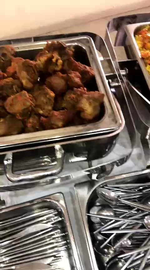 Buffet setup and service — Chafing dishes, plates and cutlery laid out and warming before guests are served.