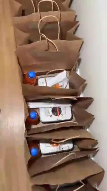 Packing lunch packs — Individual lunch packs assembled with drinks and bagged for a corporate delivery.