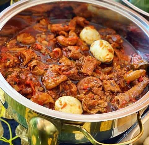 Assorted meat stew with boiled eggs in a gold-rimmed chafing dish